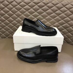 Close-up of the chunky rubber sole and polished leather upper of a black loafer.