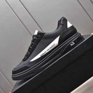 Side view of the Armani Exchange Low-Top Sneaker Black White on a grey background highlighting the white A|X logo.