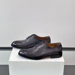 Close-up of the Berluti Nero Grigio leather upper highlighting the detailed Scritto calligraphy and brogue perforations.