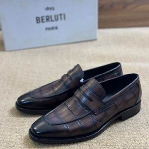 Side profile of Berluti alligator loafers showing the distinct scale texture and hand-painted brown patina.