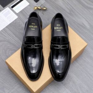Top-down and side profile views of black alligator leather loafers with distinct scale patterns and a classic penny strap on a neutral background.