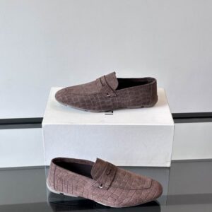 Pair of brown suede Berluti loafers with an embossed crocodile texture, low profile, and traditional penny loafer strap, displayed on a white shoebox.