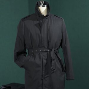 A midi-length, technical black trench coat featuring a stand collar, zippered front, belted waist, and a detachable down-filled interior liner.
