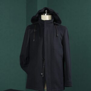 A close-up of a black wool safari jacket with four front pockets displayed on a wooden hanger against a dark green backdrop.