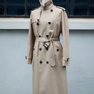 A midi-length, double-breasted khaki trench coat featuring a belted waist with a leather buckle, shoulder epaulets, and a structured turn-down collar.
