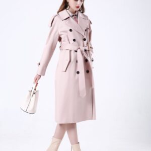 A midi-length, double-breasted cotton trench coat featuring a unique double-belted waist, relaxed raglan sleeves, and classic shoulder epaulets.