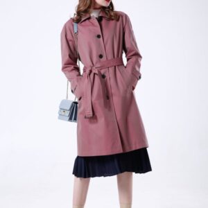 A midi-length, single-breasted beige cotton trench coat featuring raglan sleeves, a belted waist with a leather buckle, and a clean, straight-cut silhouette.