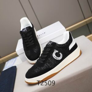 A pair of Dior B-Series Black Canvas and Suede Sneakers displayed on a grey surface, showing the monogrammed upper, white circular logo, and gum outsole.