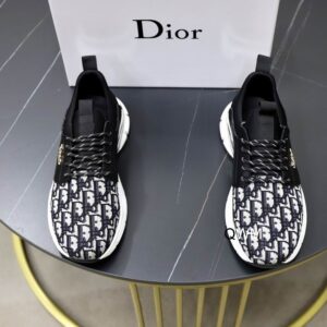 Top-down view of DIOR B24 sneakers featuring blue and white Oblique canvas on the toe, black technical fabric at the heel, and thick white rubber soles.