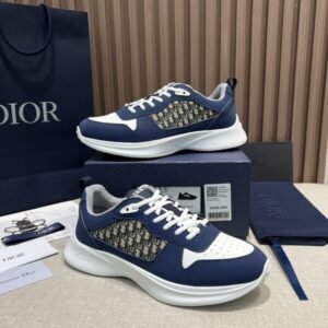 A pair of DIOR B27 low-top sneakers in white and navy blue featuring Oblique canvas side panels on top of a luxury brand box.