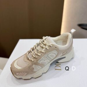 DIOR Vibe sneaker featuring white shearling uppers, gold-tone "CD" logo embroidery, and a thick, sculpted white and beige rubber sole.