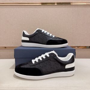 A profile view of the Dior B01 Black and White Embossed Leather Sneakers resting on a blue box, showing the monogrammed side panels and black suede toe.