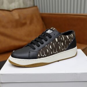 black leather low-top sneakers with brown and white zebra-patterned canvas side panels and white rubber soles featuring a custom Dior logo on the tongue.