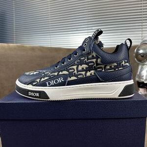 Deep Navy and Beige Dior B27 low-top sneakers shown from a side and top-down perspective, featuring the signature Oblique pattern and a blue Dior box.