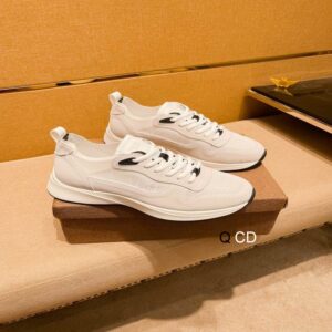 A pair of off-white and beige Dior B27 sneakers being held, showing the cream leather construction and the beige Dior Oblique monogram on the side.