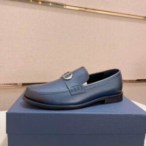 Dior Blue Grained Leather Buckle Loafer featuring a navy blue textured upper and a silver metal buckle sitting on a blue box.