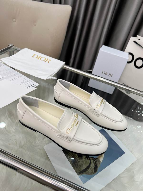 A pair of DIOR Granville Loafers in beige suede with Dior Oblique jacquard vamps resting on a blue branded shoe box.