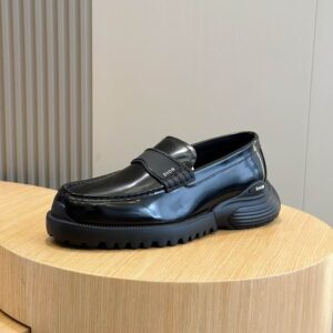 Dior Polished Black Leather Chunky Sneaker Loafer with a thick serrated sole and a matte black logo strap displayed on a wooden pedestal.