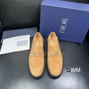 Tan suede Dior-inspired loafers with metal buckle displayed on black leather surface