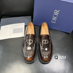 A pair of Dior Timeless Loafers in Burnished Burgundy Brown leather with silver CD buckles, displayed next to a blue branded box and dust bag.