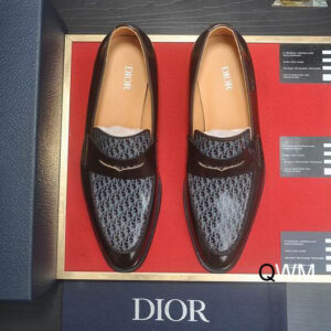 Top-down view of Dior Timeless Loafers in Grey Oblique Jacquard with black leather trim and penny straps on a red display background with blue Dior packaging.