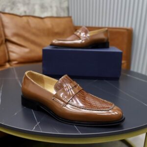 Top-down view of DIOR Timeless Oblique Pattern Leather Loafers in cognac brown on a grey marble table.