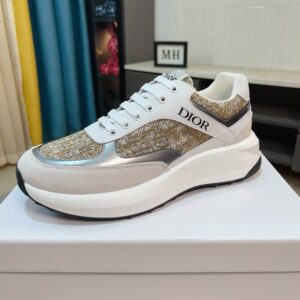 Dior Vibe low-top sneakers featuring gold-tone Dior Oblique monogram fabric, white leather panels, and a thick, architectural white rubber sole.