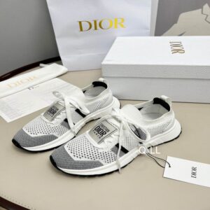 Top-down view of Dior Vibe Low-Top Sneakers in white mesh and black technical fabric with white laces, placed on a table next to a Dior box.