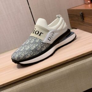 Dior Vibe slip-on sneakers featuring grey Oblique technical fabric, a branded "Christian Dior" elastic band, and a white architectural rubber sole.