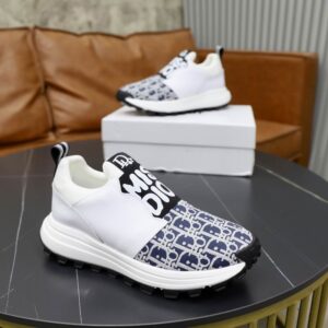 A pair of white and blue DIOR Vibe sneakers featuring the Oblique monogram toe and a "MISS DIOR" logo elastic strap on a black marble table.