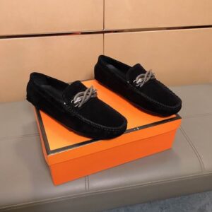 Pair of Gucci Black Suede Loafers with silver snake hardware resting on an orange box.