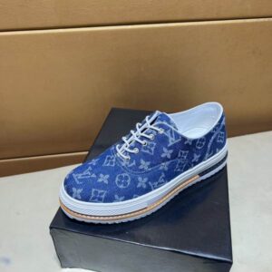 Blue Denim Monogram Platform Sneakers with white laces and a multi-layered white and natural-toned sole, displayed on a black surface.