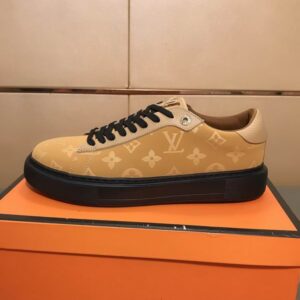 beige low-top sneakers with an all-over Louis Vuitton-inspired monogram pattern, featuring black laces, a prominent black platform sole, and a tan lining.