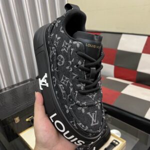 Close-up image of a black and gray Louis Vuitton Monogram Platform Trainer Sneaker, showcasing the repeating LV logo pattern and the chunky black sole with white 'LOUIS VUITTON' lettering