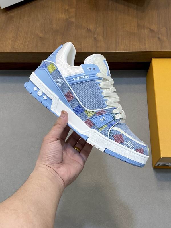 Louis Vuitton Trainer Sneakers in light blue denim with a colorful Damier pattern on a grey background.