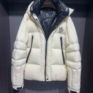 Cream puffer jacket with black zip detail and a detachable logo hood, hanging on a gold-toned rack.