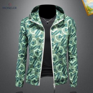 Moncler lightweight hooded jacket in a green and teal all-over monogram logo print, styled on a mannequin over a black t-shirt with a silver necklace.
