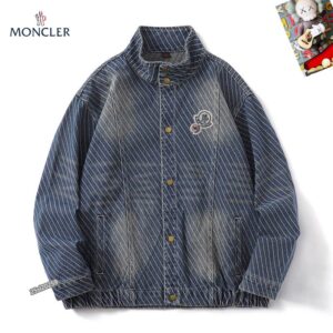 Moncler-style blue denim jacket with diagonal white stripes, a stand collar, and gold-tone snap-button closures over a central zipper. Features a circular logo patch on the chest.