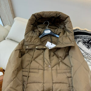 Rich mocha brown classic puffer jacket with a high collar and logo patch hanging on a metal clothing rack next to green, pink, and tan jackets.