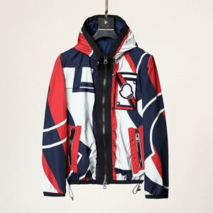 A lightweight, hooded windbreaker jacket with a bold, abstract geometric pattern in red, white, and navy blue. It has a black full zip and a circular logo patch on the left chest.