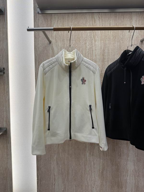White or cream fleece zip-up jacket with quilted shoulder panels, a stand collar, and a tricolor embroidered logo patch, displayed on a retail hanger.