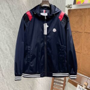 Navy blue Moncler-style hooded windbreaker jacket with red shoulder accents and white striped cuffs.