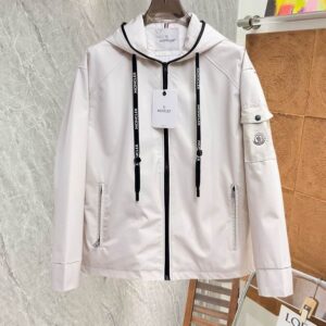 Image of a light cream/off-white hooded technical jacket with black contrast zipper and hood drawstrings featuring white logo taping. It includes a utility patch pocket on the left sleeve and zippered waist pockets