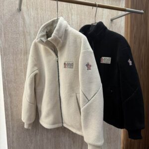 Back view of a cream high-pile fleece zip-up jacket featuring a technical grey nylon panel with a triangular detail across the upper back