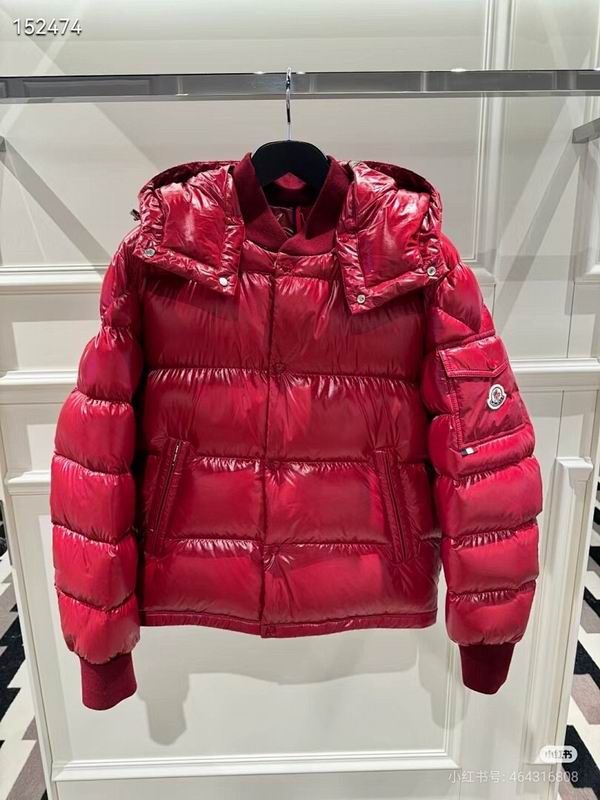 A vibrant high-shine red puffer jacket with horizontal quilting, featuring a detachable hood and a snap-button pocket on the left sleeve with a logo.