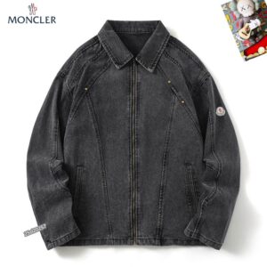 Moncler-style washed black denim jacket with a front zip closure, a classic collar, and angled chest seams with metal stud details. A small logo patch is visible on the left sleeve.