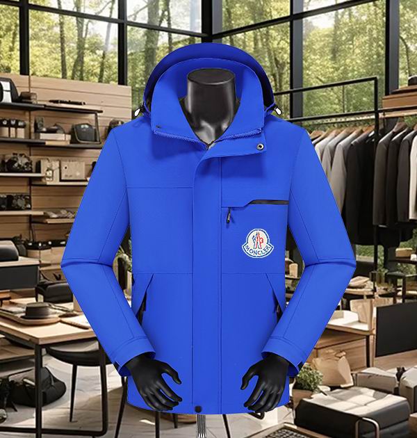 Navy blue men's Moncler-style weatherproof jacket displayed on a mannequin, featuring a high collar, an angled chest pocket with a zipper, and a small, minimal multicolored logo on the upper left chest.