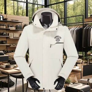 Navy blue men's Moncler-style weatherproof jacket displayed on a mannequin, featuring a high collar, an angled chest pocket with a zipper, and a small, minimal multicolored logo on the upper left chest.