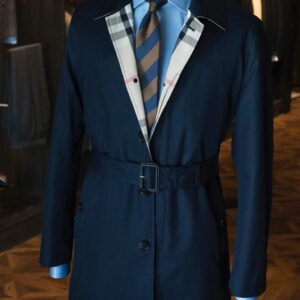A midi-length, straight-silhouette single-breasted trench coat in navy waterproof cotton featuring a concealed front closure, a belted waist, and kissing buttons on the cuffs.