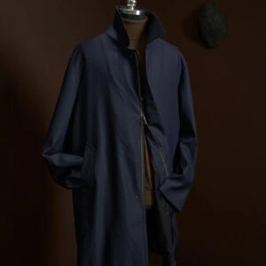 A midi-length, single-breasted navy wool coat featuring a hidden zipper and snap closure, a classic turn-down collar, and a clean, straight-cut silhouette.